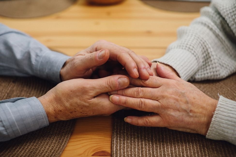 Caregiver holding the hands of an elderly person